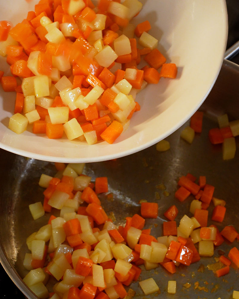 Fried diced potatoes and carrots set aside in a bowl for Giniling