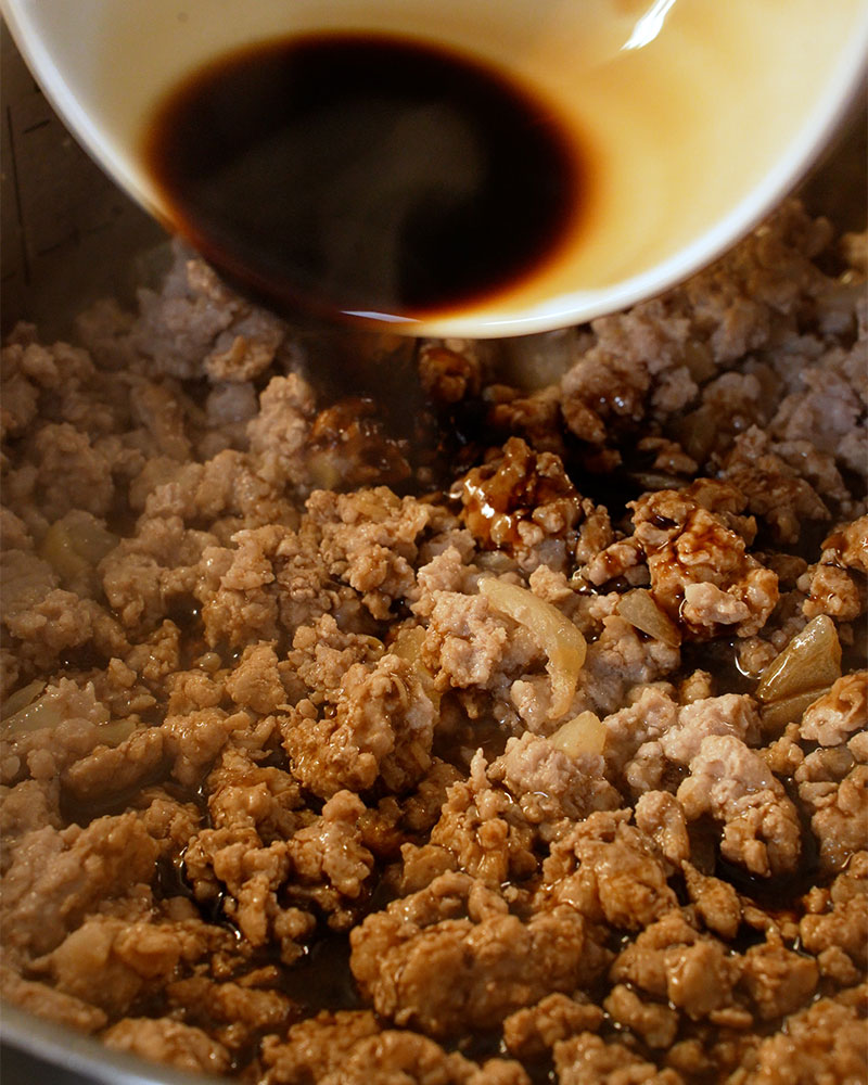 Soy sauce and vinegar poured over cooked ground pork for Giniling